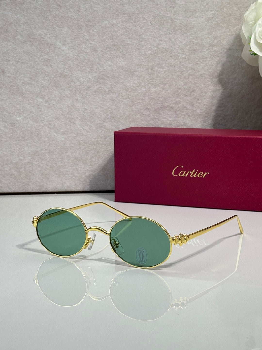 Cartier round metal glasses with gold frame and green-tinted lenses