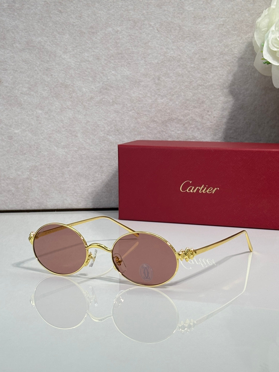 Cartier round metal glasses with gold frame and rose-tinted lenses