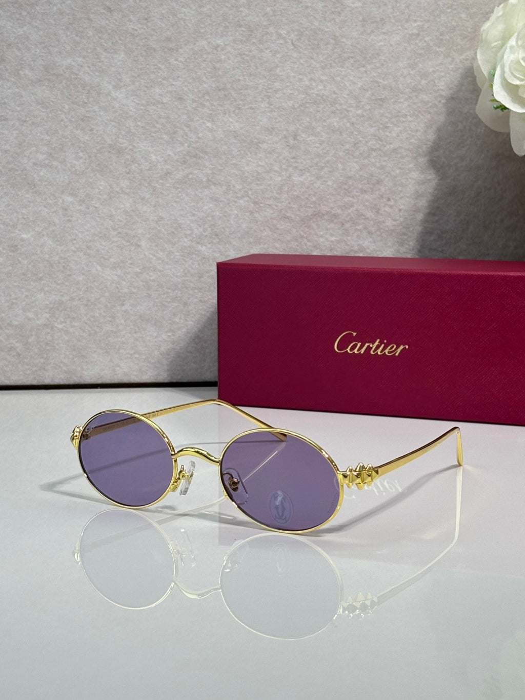 Cartier round metal glasses with gold frame and lavender-tinted lenses