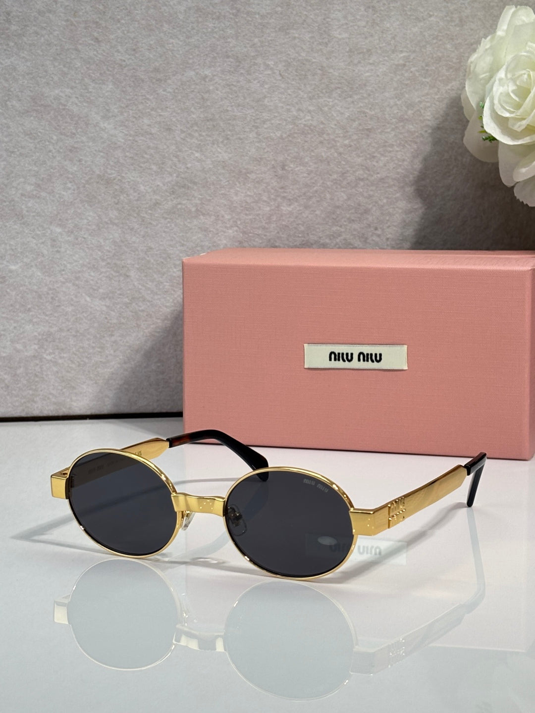 MiuMiu round sunglasses with gold-tone frame and dark lenses