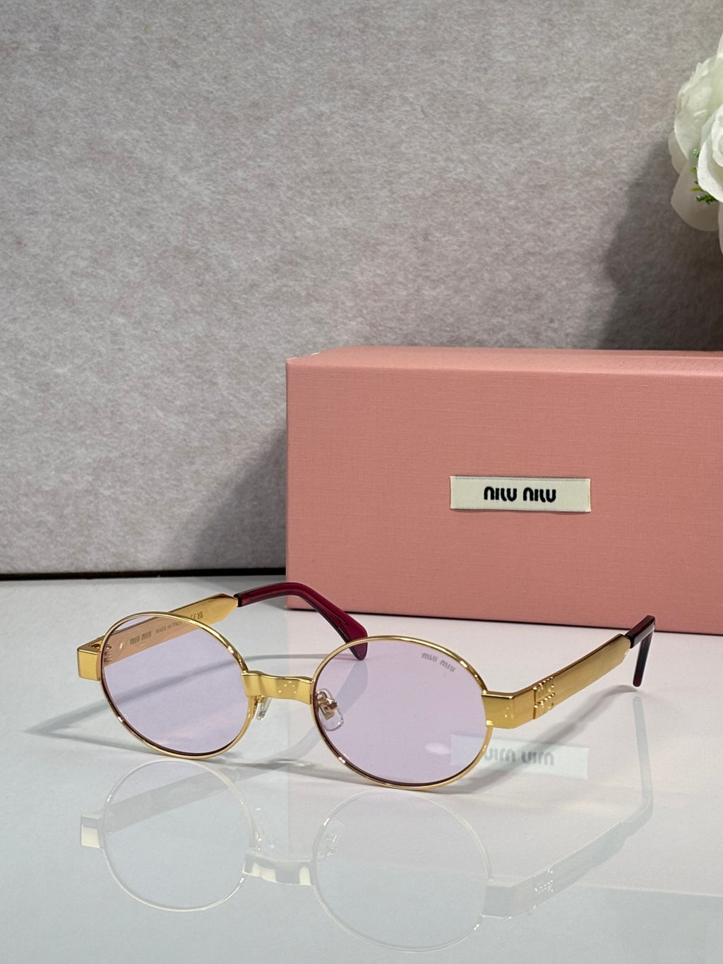 MiuMiu round sunglasses with gold-tone frame and burgundy temple accents