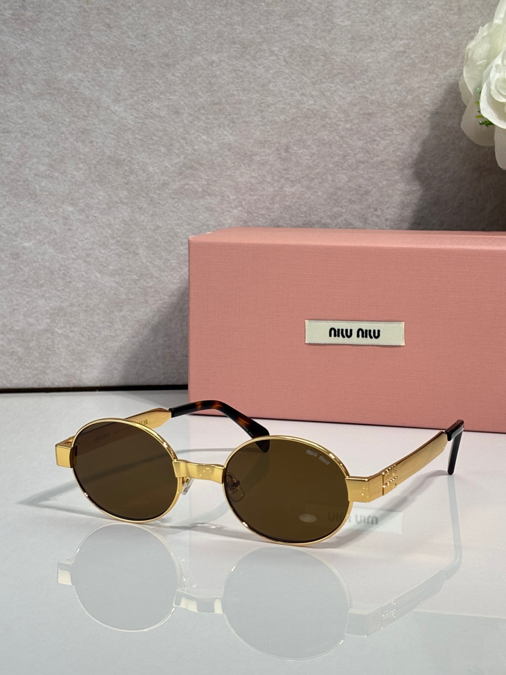 MiuMiu round sunglasses with gold-tone frame and dark lenses
