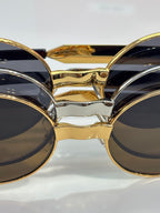 MiuMiu round sunglasses close-up of gold bridge and dark lenses
