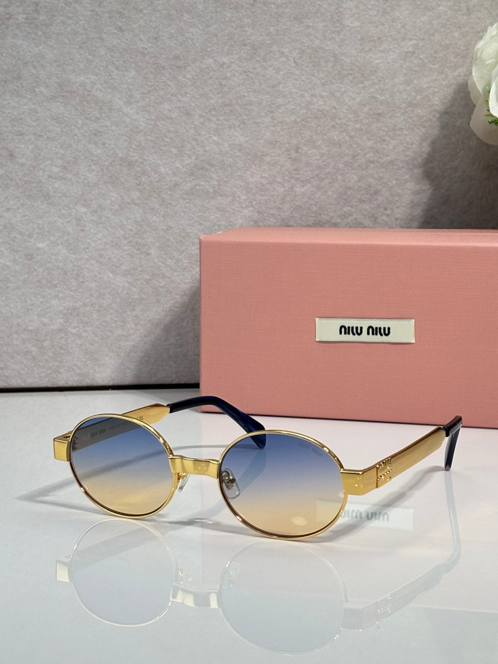 MiuMiu round sunglasses with gold-tone frame and blue-tinted lenses