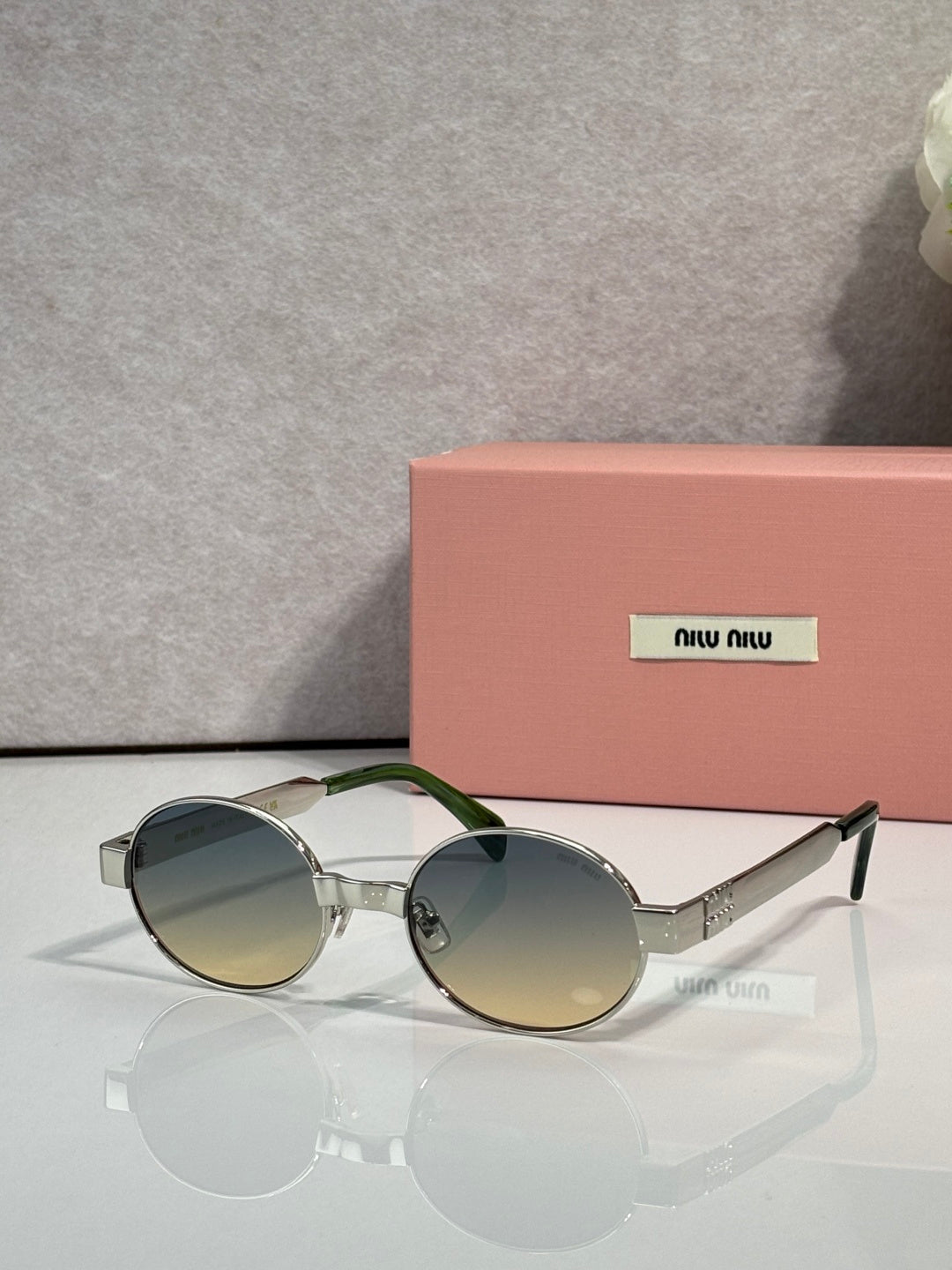 MiuMiu round sunglasses with silver-tone frame and green-tinted lenses