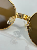 MiuMiu sunglasses close-up of gold-tone hinge and clear nose bridge