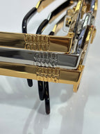 MiuMiu sunglasses close-up of gold-tone logo arms with black accents
