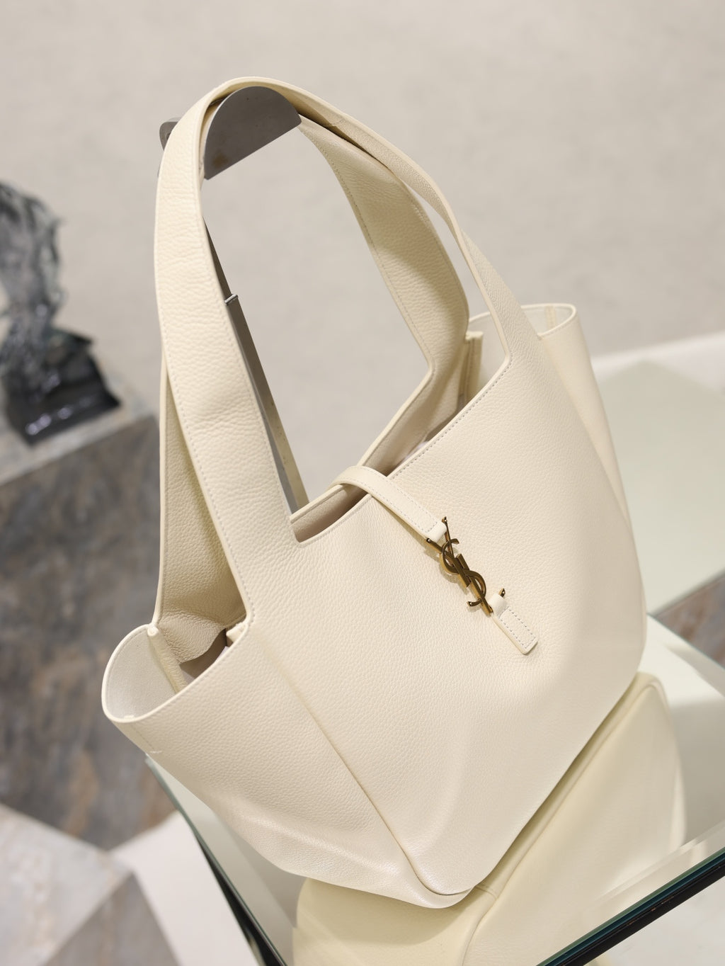 YSL cream tote bag with two long handles and gold emblem clasp