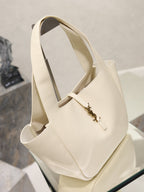 YSL cream tote bag with two long handles and gold emblem clasp