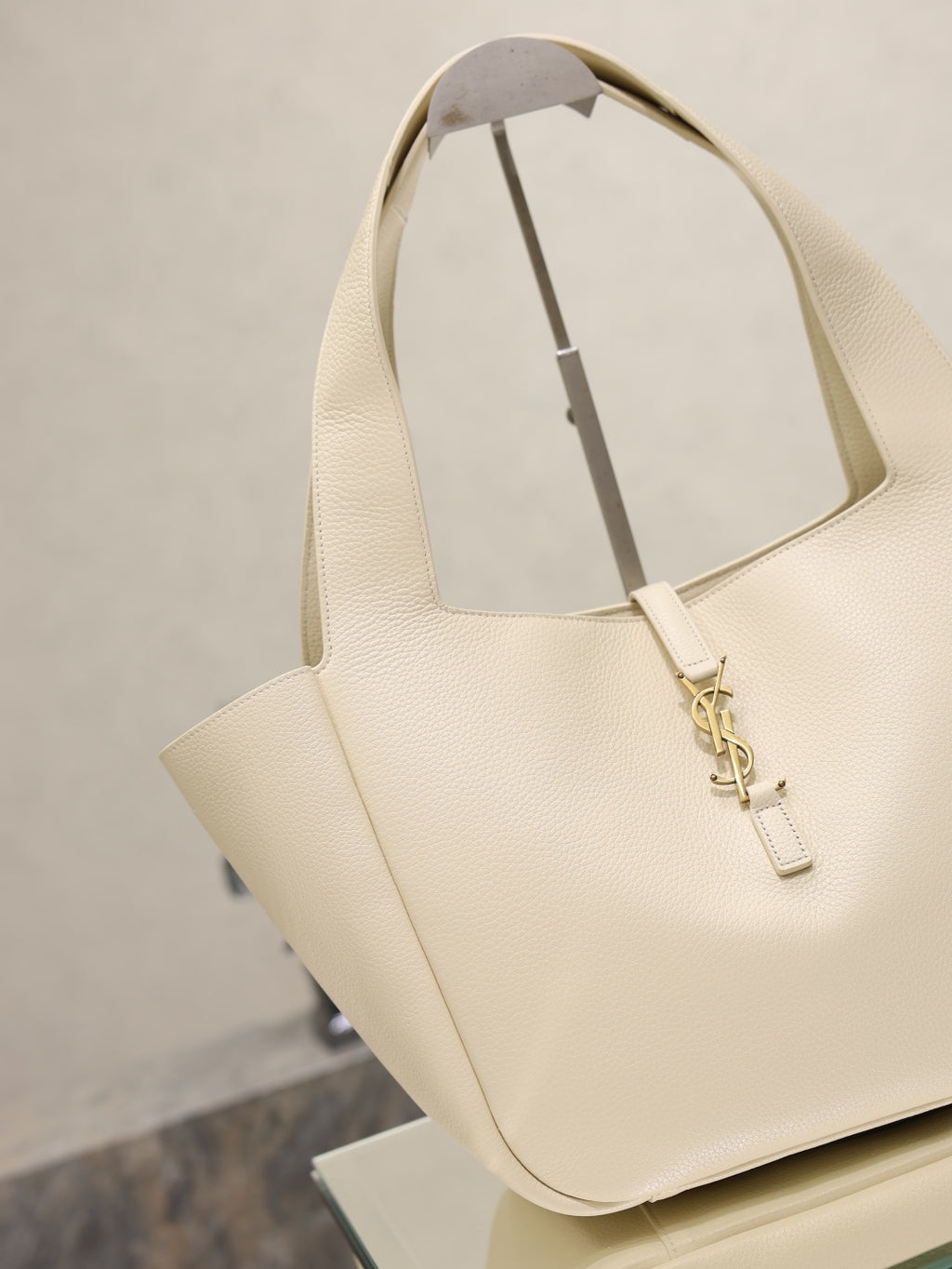 YSL cream tote bag with angled handles and gold emblem clasp