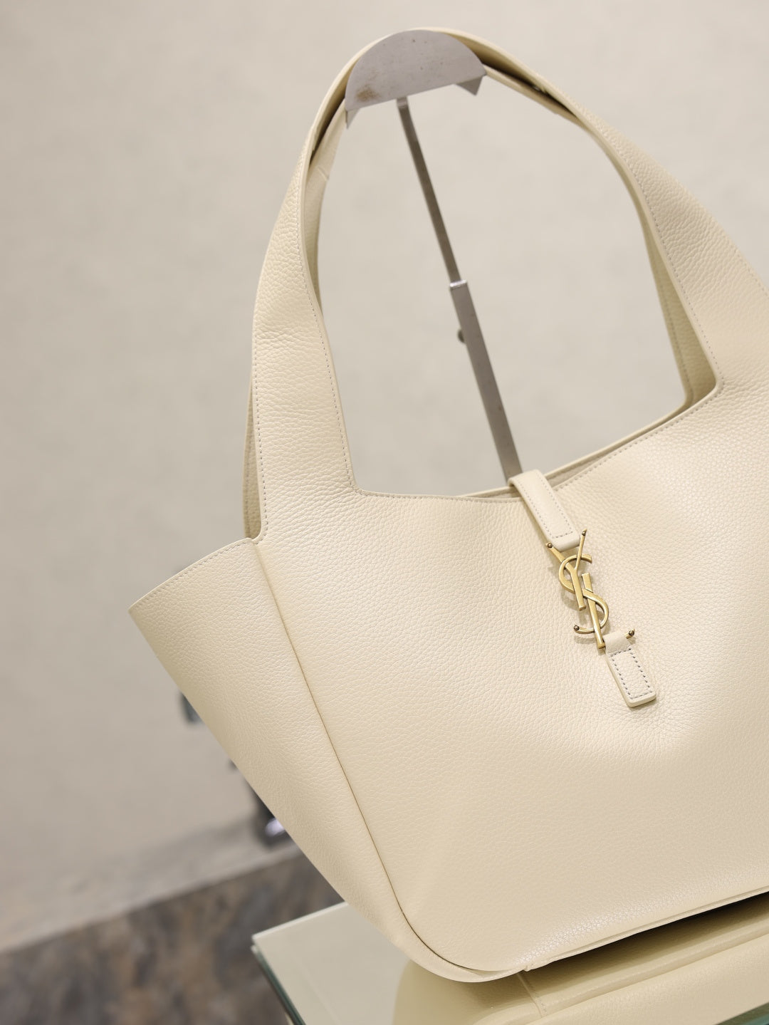 YSL cream tote bag with angled handles and gold emblem clasp