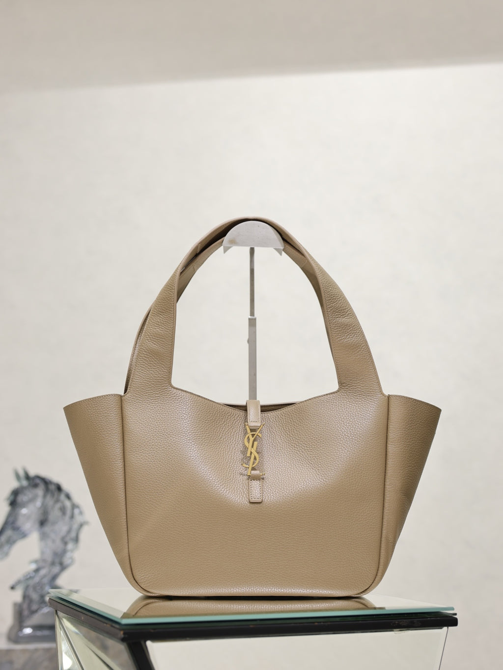 Beige leather YSL tote bag with top handles and gold logo detail at center front