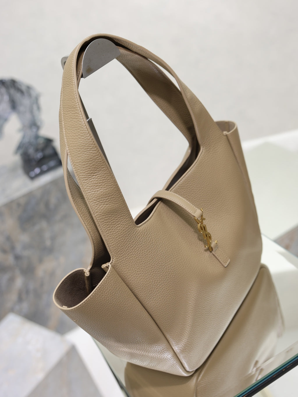 Beige leather YSL tote bag side view with top handles and front logo detail