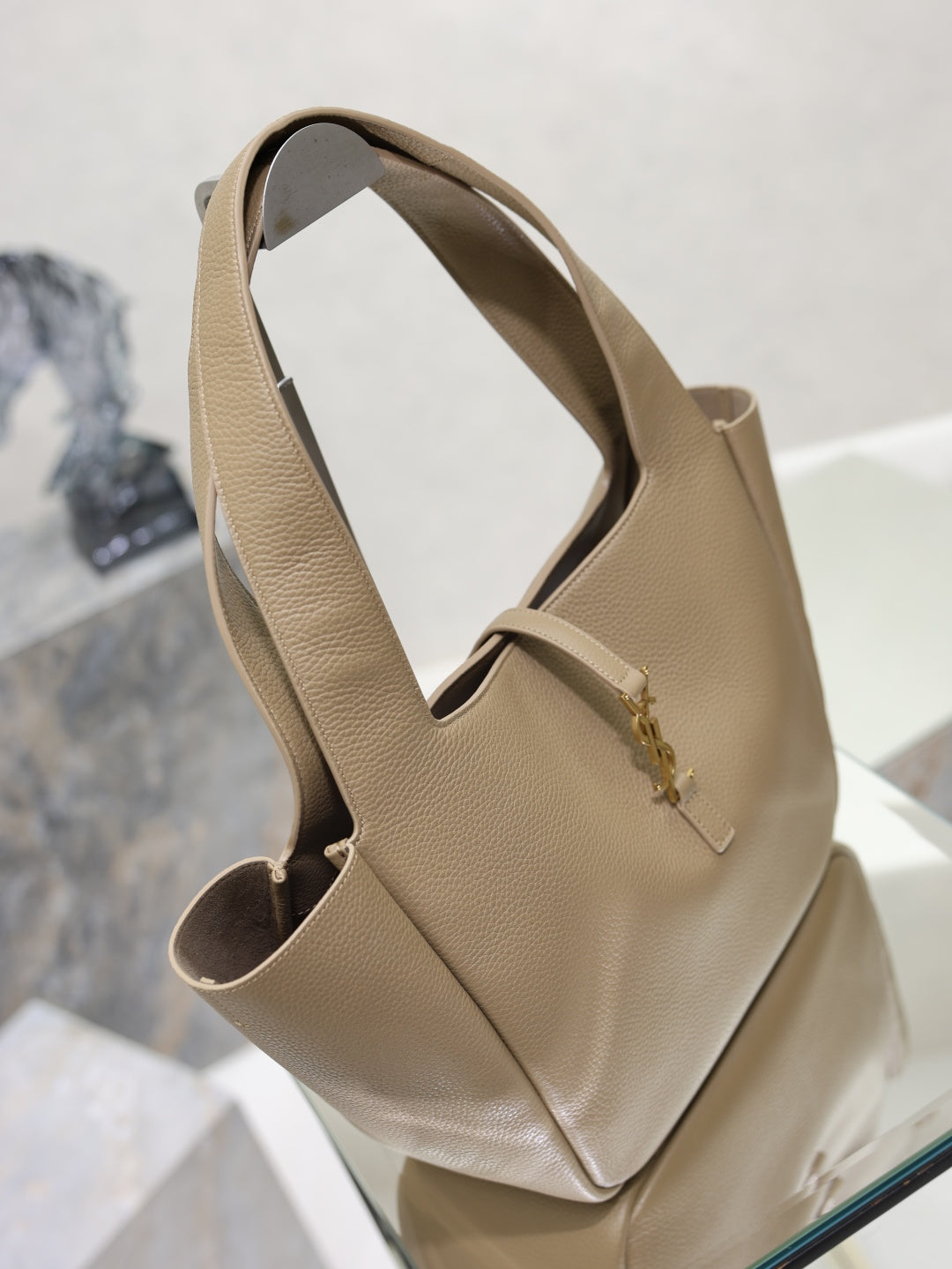 Beige leather YSL tote bag side view with top handles and front logo detail