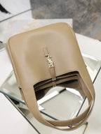 Beige leather YSL tote bag top view with gold logo plaque and front strap