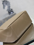 Beige leather tote bag close-up of folded edge seam and smooth textured surface