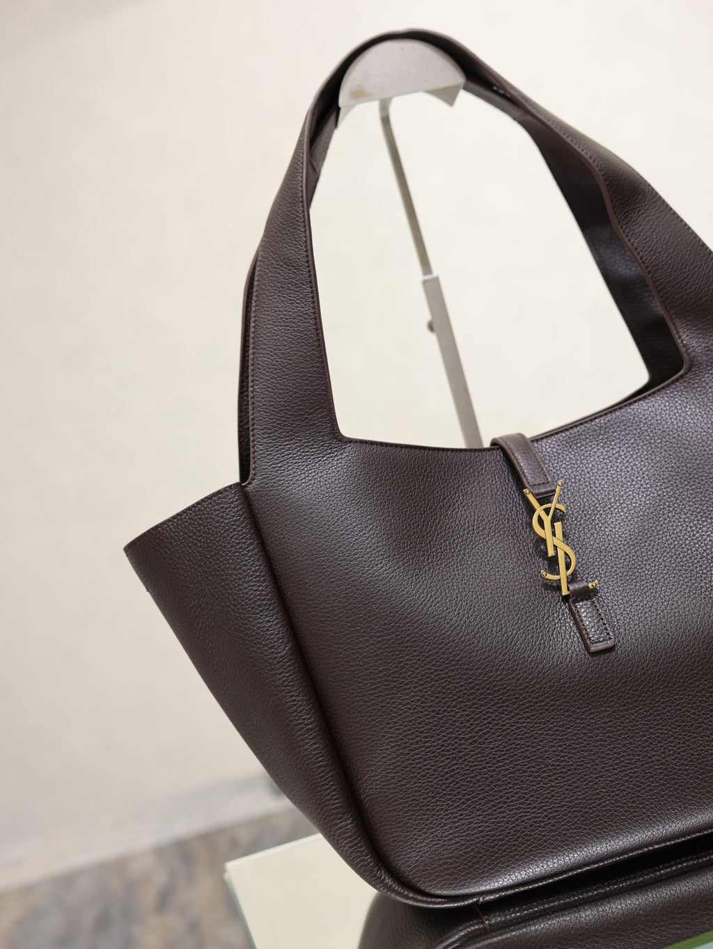 YSL bag tote with dark pebbled leather, gold YSL logo charm, and open top