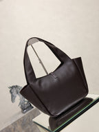 YSL bag tote back/side view in dark pebbled leather on glass display
