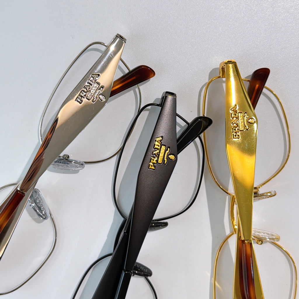 Prada eyeglasses set showing black, gold, and tortoise frames