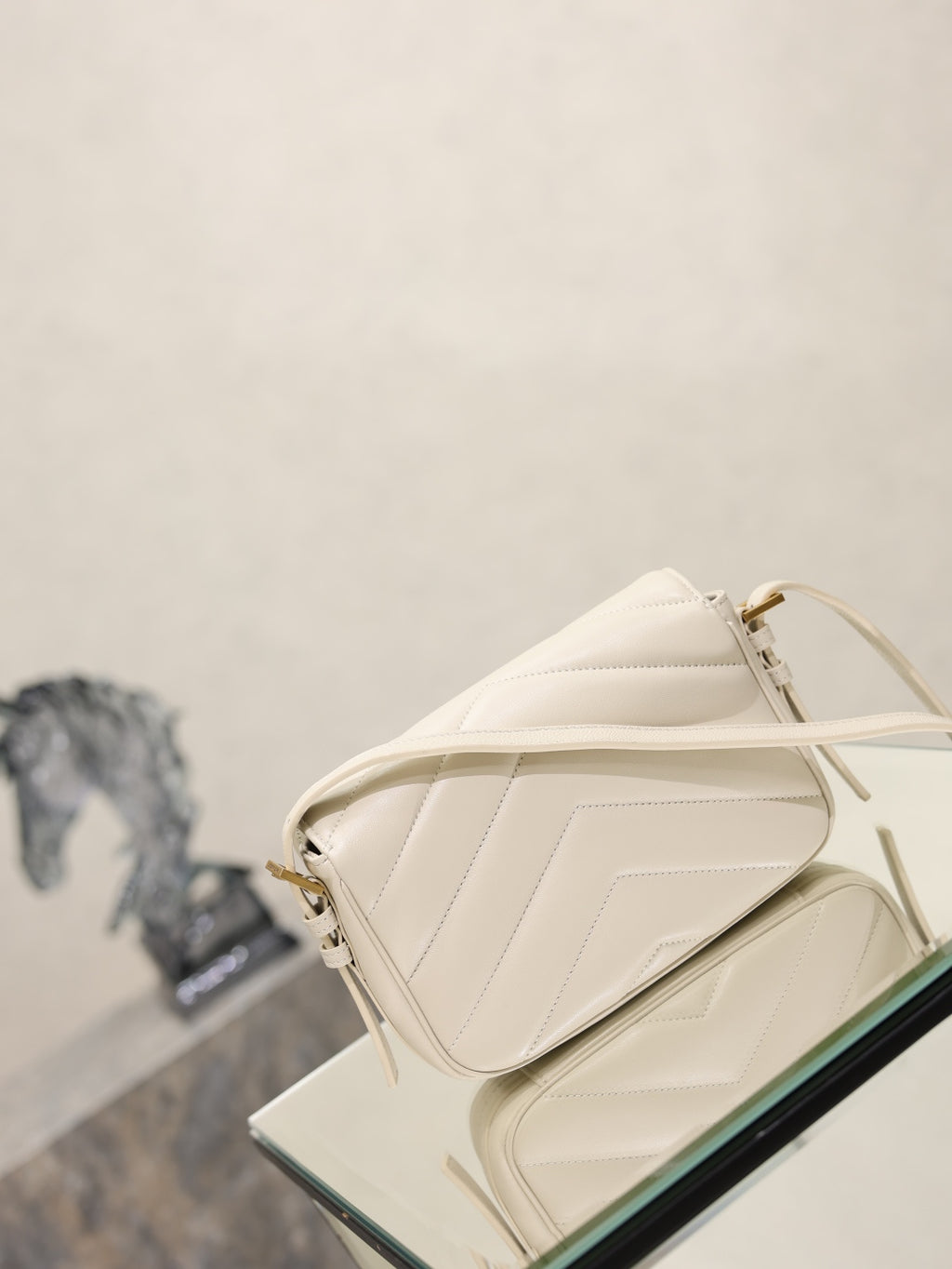 Cream quilted YSL crossbody bag angled view with top flap and adjustable strap