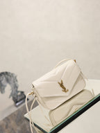 Cream quilted YSL shoulder bag angled view with gold-tone logo and tassel ties