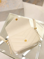 Cream YSL flap bag top view with snap button clasp and gold hardware