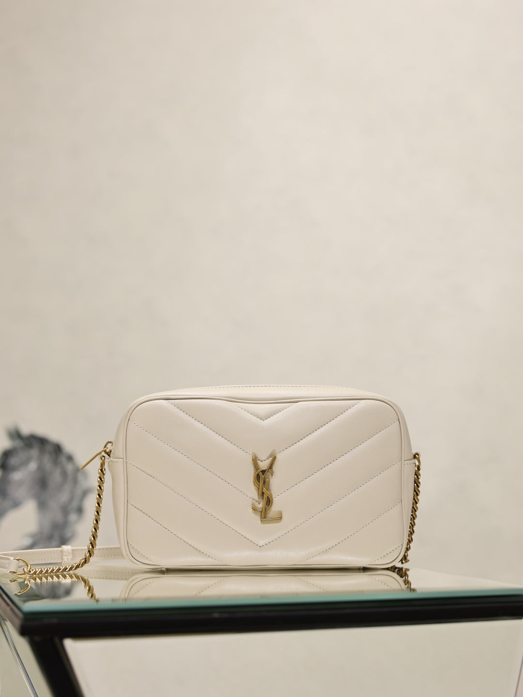YSL quilted cream crossbody bag with YSL logo clasp and gold chain strap