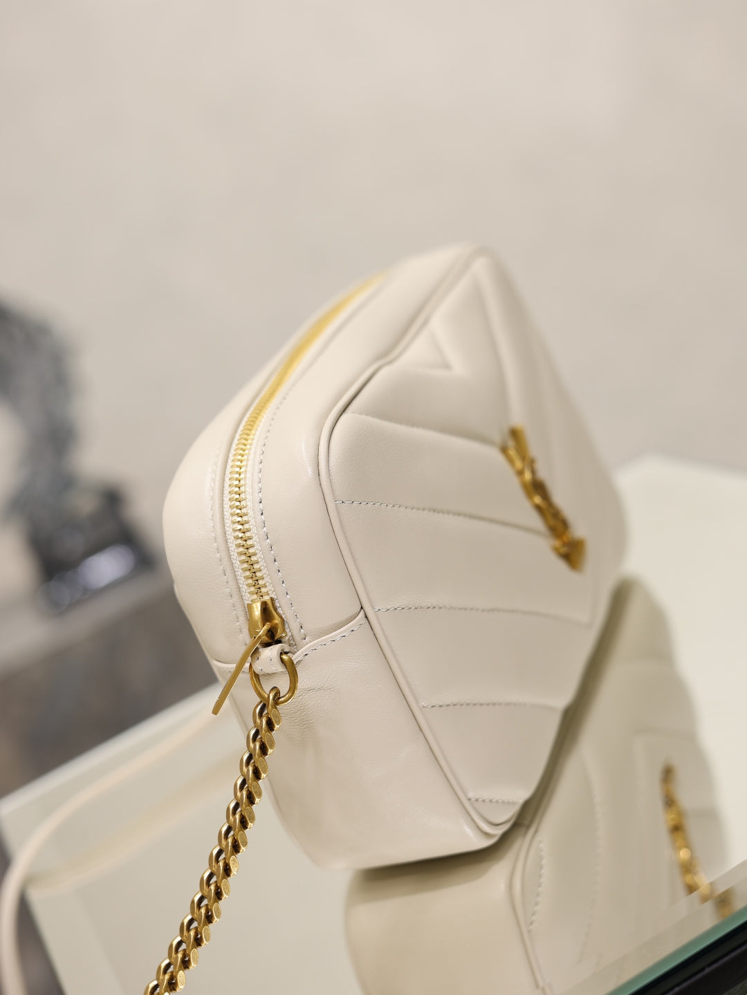 YSL cream quilted bag with gold chain strap and zip closure front view