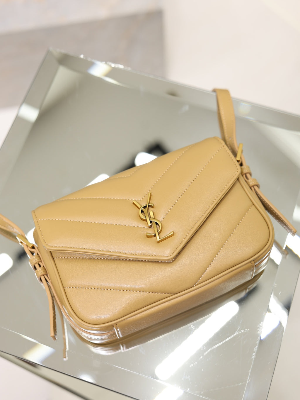 YSL quilted beige crossbody bag front view with flap and gold YSL logo hardware