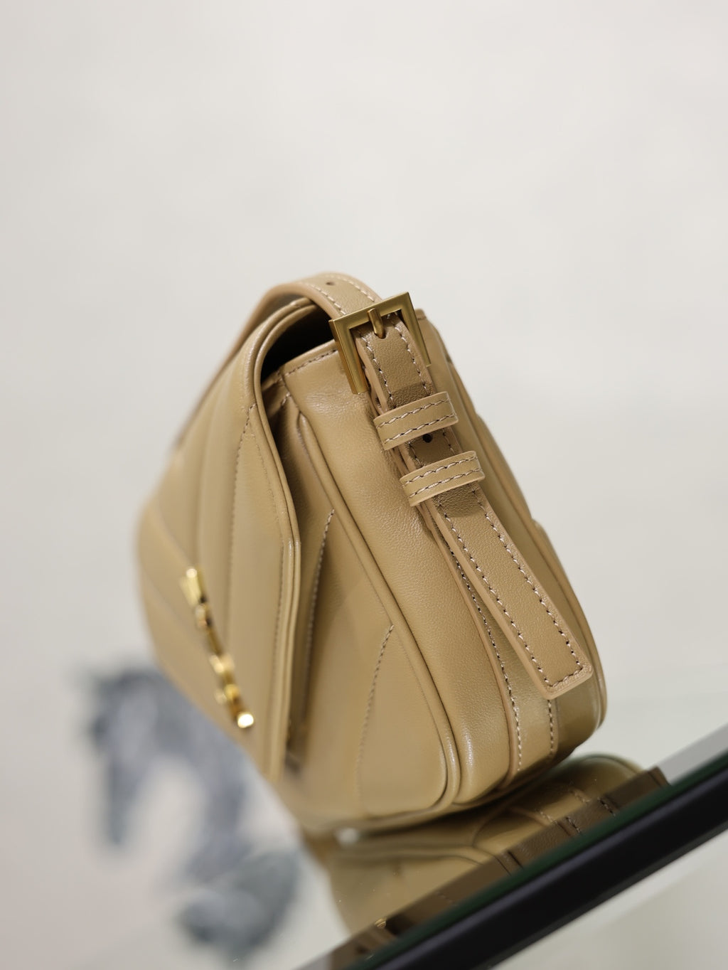 YSL beige quilted crossbody bag side view with stitched panels and gold hardware