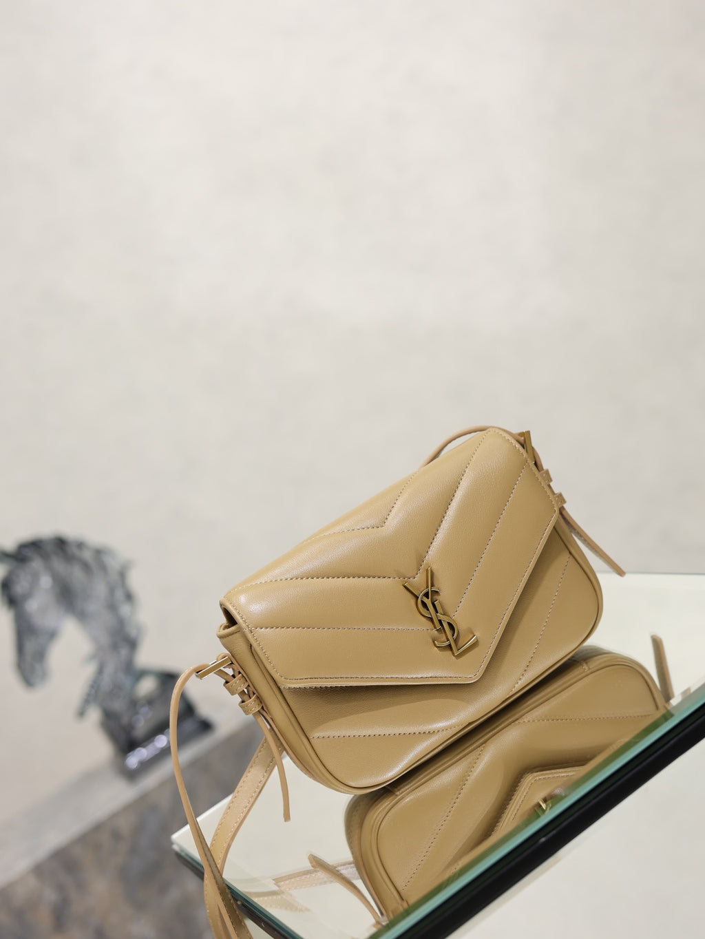 YSL quilted beige crossbody bag angled view with flap closure and shoulder strap