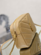 Side view of quilted leather shoulder bag with zip and chain strap, light tan