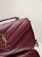 Burgundy quilted shoulder bag detail with gold YSL logo on front flap.