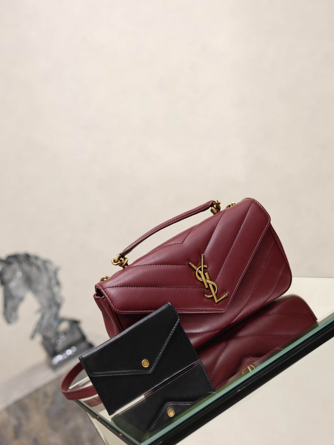 Burgundy quilted shoulder bag with gold YSL logo, front flap and chain strap.