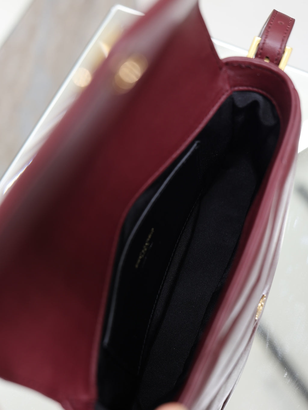 YSL quilted leather bag with burgundy interior lining, open top view