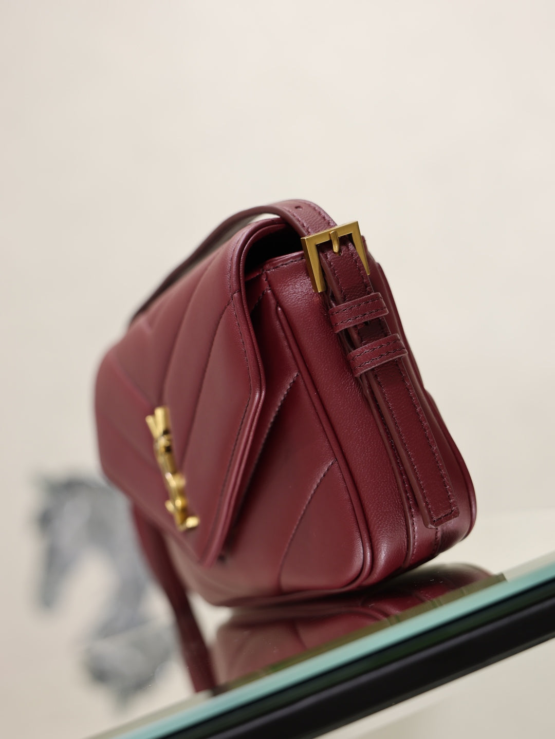 YSL quilted leather bag in burgundy, back view with gold hardware and strap