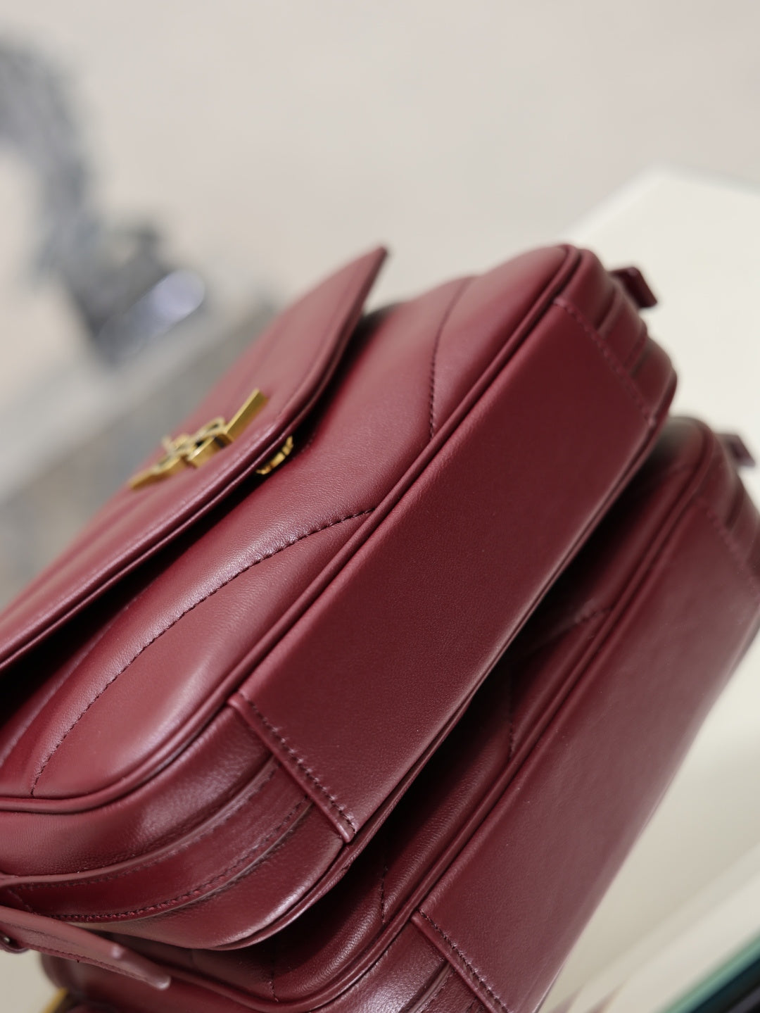 YSL quilted leather bag in burgundy, stitched side detail with strap hardware