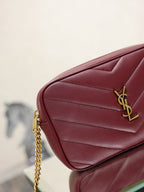 YSL bag corner view in burgundy with gold YSL logo and quilted stitching