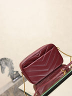 YSL bag angled view in burgundy with chevron quilting and gold chain strap