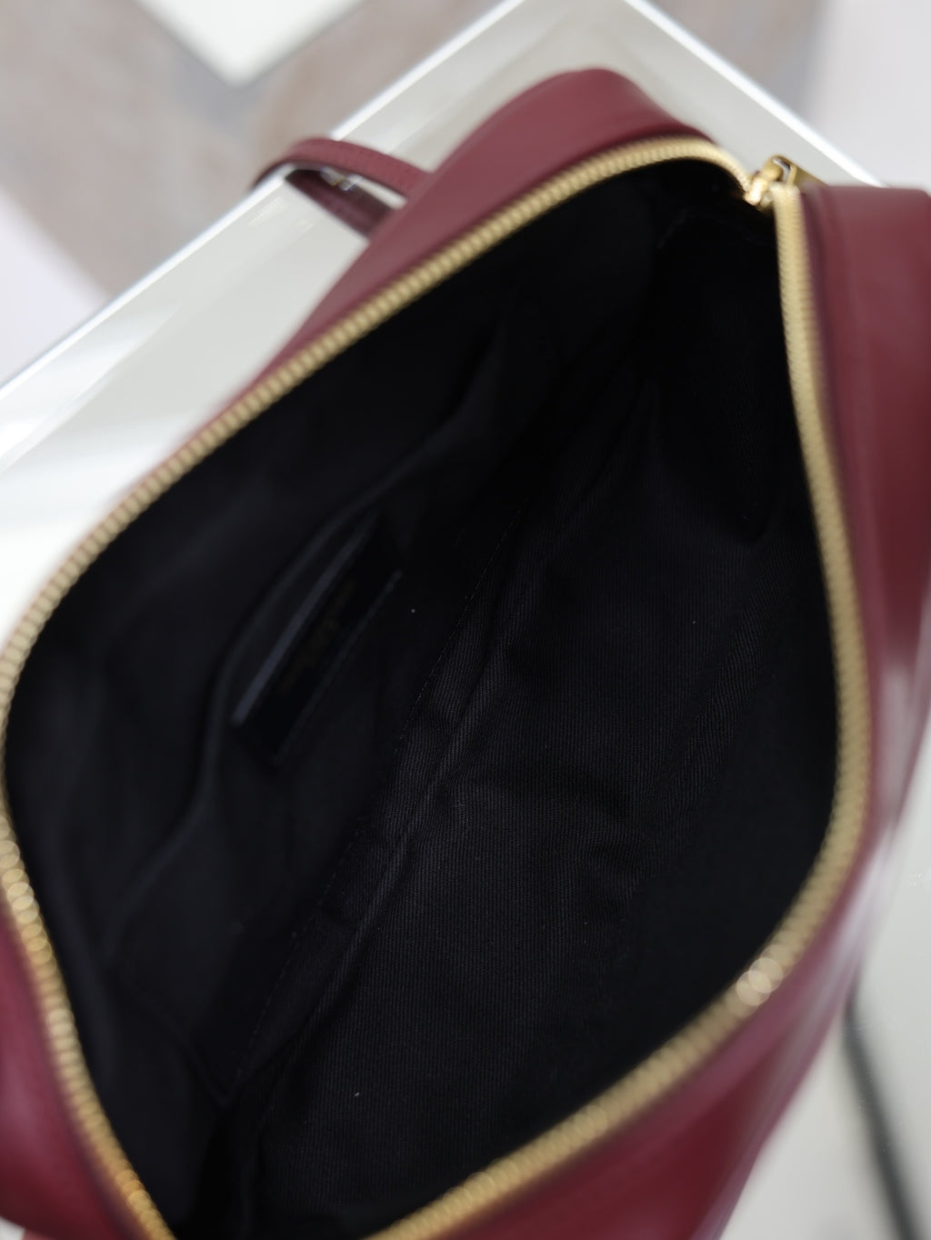 YSL bag open top showing black interior lining with gold-trimmed zipper