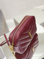 YSL bag side profile in burgundy with gold chain, YSL logo, and zip closure