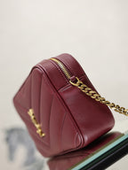 YSL bag side view in burgundy leather with gold chain and top zip detail