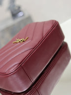 YSL bag close-up in burgundy with gold YSL logo and smooth stitched panels