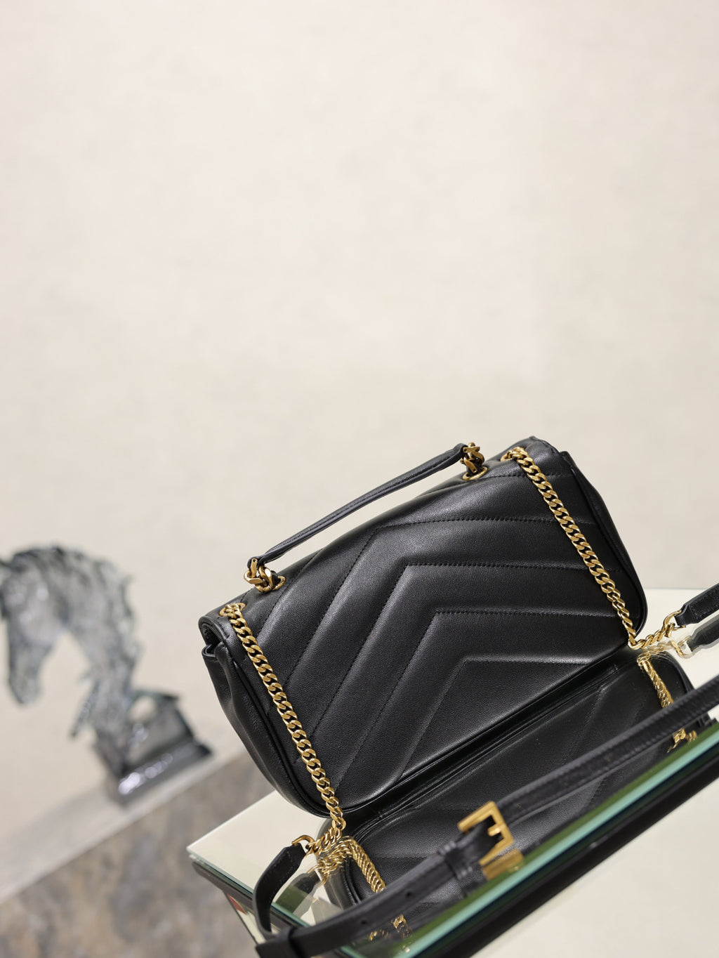 Black quilted shoulder bag with YSL logo and gold chain detail