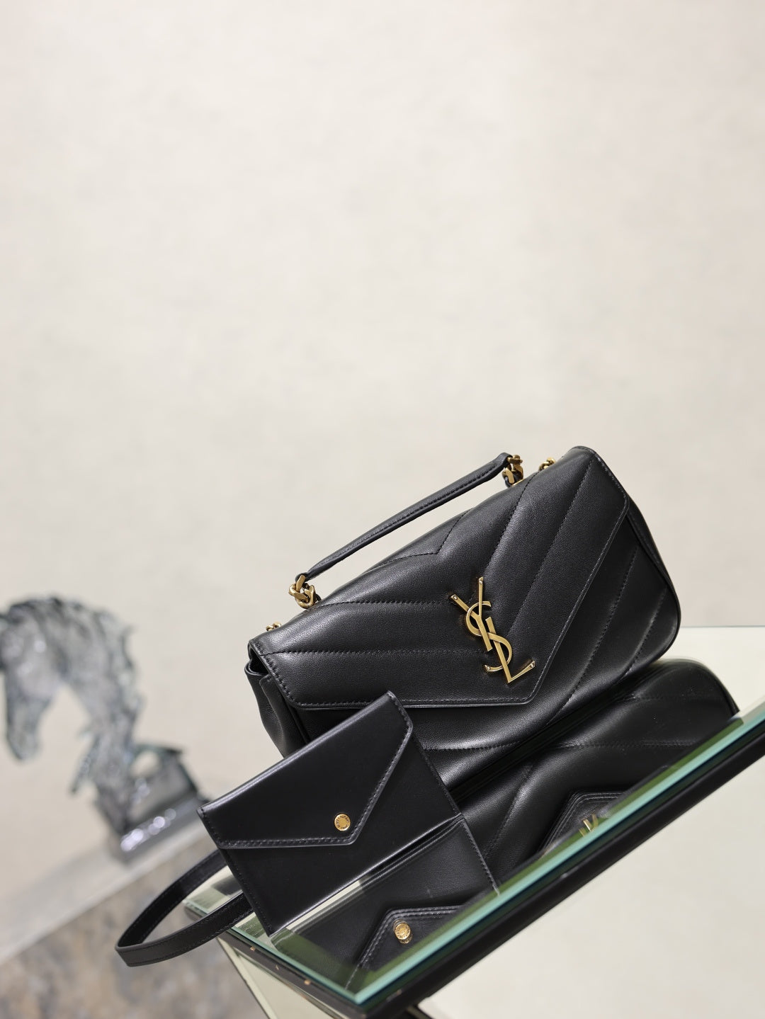 Black quilted shoulder bag with gold chain and small flat card holder