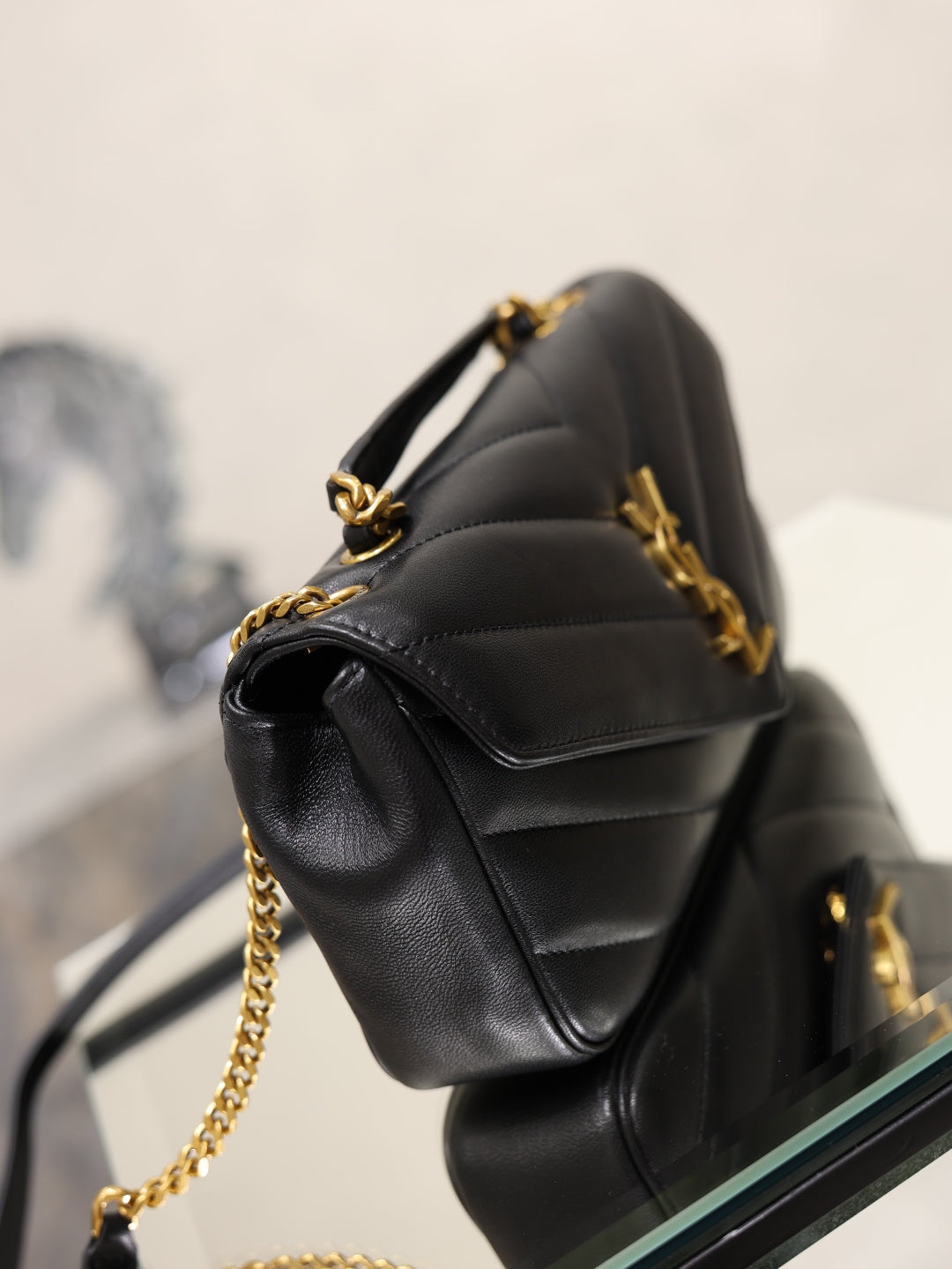 Black quilted shoulder bag with gold chain crossbody strap
