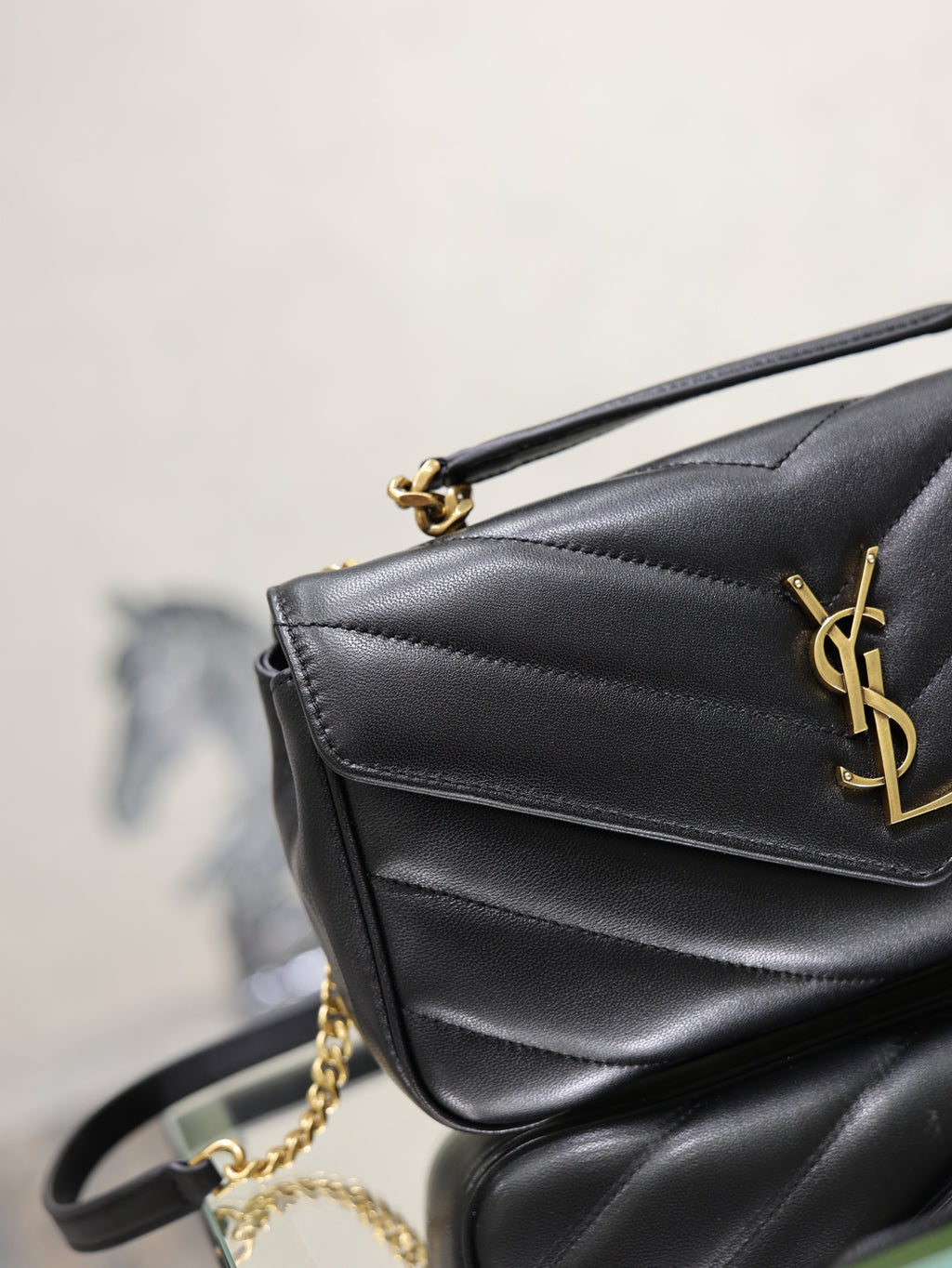 Black quilted flap shoulder bag with gold YSL logo and chain strap
