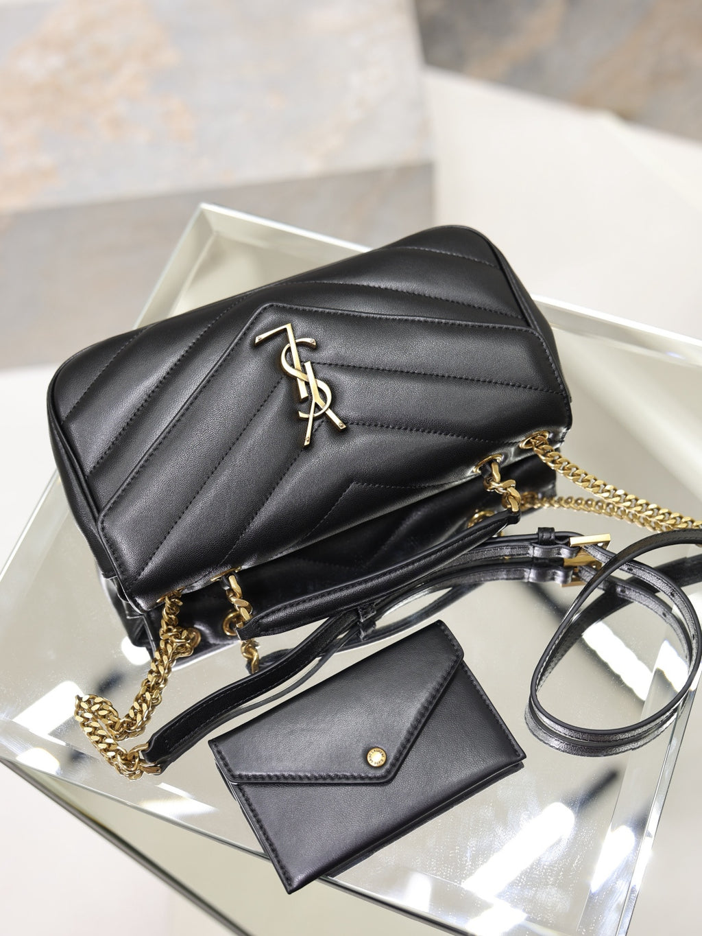 Black quilted shoulder bag with gold chain, card holder, and keyring hardware