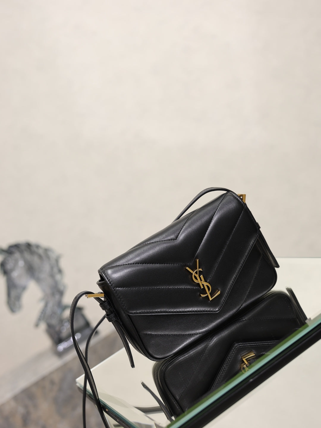 Black quilted YSL shoulder bag with gold logo on front flap