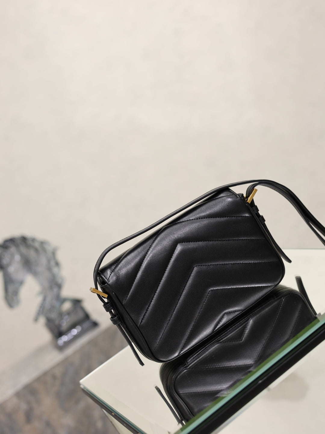 Black quilted YSL shoulder bag with top handle and side flap detail